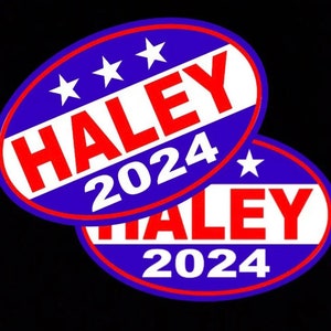 May include: Two blue and red oval stickers with white text. The stickers say "HALEY 2024" with three white stars on the top sticker.