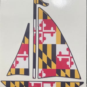 May include: A sailboat sticker featuring the Maryland state flag design. The sails display a vibrant pattern of red, white, black, and yellow, with a black mast and flag. The sticker is die-cut and ready to apply.