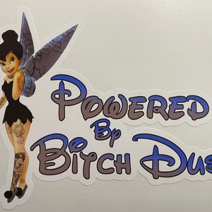May include: A sticker featuring a cartoon fairy with blue wings and tattoos. The text "Powered by Bitch Dust" is written in a stylized font with a gradient of blue and gray.