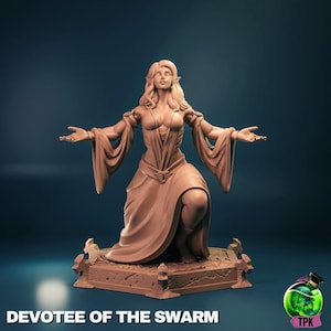 Könnte beinhalten: Detaillierte Skulptur einer knienden weiblichen Figur mit ausgestreckten Armen, die ein fließendes Gewand trägt. Die Figur hat spitze Ohren und langes Haar. Der Sockel der Skulptur hat ein dekoratives Design. Der Text "DEVOTEE OF THE SWARM" steht unten.