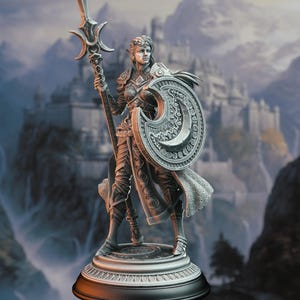 May include: A silver-toned fantasy figurine of an elf warrior standing on a circular base. The figure wears intricate plate armor, holds a tall polearm with a crescent-shaped top, and carries a large, ornate shield with a crescent moon design.