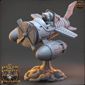 May include: A grey miniature aeroplane model featuring a pilot wearing a fur-lined hat in the cockpit, a front propeller, and two side-mounted engines. The aircraft is mounted on a sculpted cloud base, with the text Daybreak Miniatures and The Tenacious Tinkerkers of Todthaven visible.
