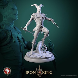 Può includere: Una statuetta grigia dettagliata di un giullare che tiene due pugnali, posata su una base di pietra. Il giullare indossa un costume con un motivo a diamante e un cappello con le corna. Il logo Iron King è visibile in basso.