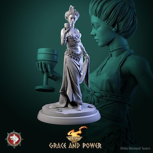 May include: A grey resin miniature figurine of a standing figure holding a chalice, set on a circular base. The figure wears a draped gown with a decorative waist belt. A floating hand holds a second chalice. Text reads Grace and Power.