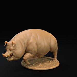 May include: A tan-colored figurine of a wild boar with an aggressive stance. The boar has visible tusks and is posed on a small, round base. The sculpture has detailed musculature and is set against a dark background.