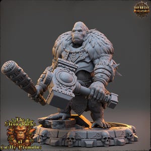 May include: A gray miniature figurine of a gorilla-like creature holding a large hammer and a club. The figurine is standing on a stone base with skulls. The text "The Strongbacks of Castle Primatus" is at the bottom.