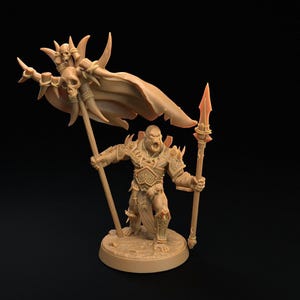 Könnte beinhalten: Eine hellbraune Miniaturfigur eines Kriegers auf einem runden Sockel. Die Figur trägt eine verzierte Rüstung, hält einen Speer in der einen Hand und trägt in der anderen Hand ein großes Banner, das mit Totenköpfen und Dornen verziert ist.