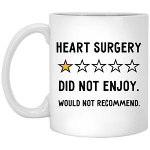 Pu&ograve; includere: Tazza da caff&egrave; in ceramica bianca con una grafica nera e gialla che recita "HEART SURGERY DID NOT ENJOY. WOULD NOT RECOMMEND." con una valutazione di una stella.