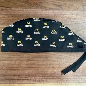May include: Black scrub hat with a repeating pattern of the text "EW, DAVID" in yellow.