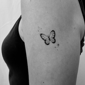 petit tatouage de papillon noir et blanc