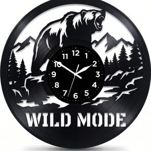 May include: Black vinyl record clock featuring a bear silhouette with an open mouth, mountains, and trees. The clock face is black with white numbers and hands. The words "WILD MODE" are cut out at the bottom.