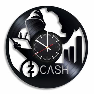 May include: Black vinyl record clock with a white silhouette of a hooded figure holding a tablet, a clock face, and the text "Z CASH".