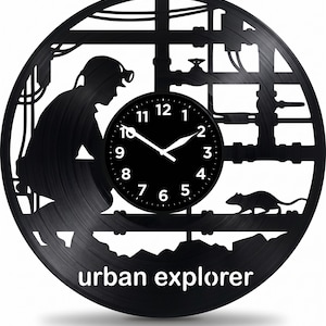 May include: Black wall clock made from a vinyl record, depicting a worker, pipes, and a rat. The clock face is black with white hands and numbers. The words "urban explorer" are at the bottom of the clock.