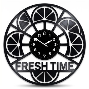 Puede incluir: Reloj de pared negro con un diseño circular que presenta rodajas de naranja estilizadas y las palabras "FRESH TIME". La esfera del reloj es negra con números y manecillas blancas. El reloj es un artículo decorativo.