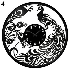 May include: Black peacock-themed wall clock. The clock features a cut-out design of a peacock with its feathers spread, and a circular clock face with black hands and white numbers. The clock is round.