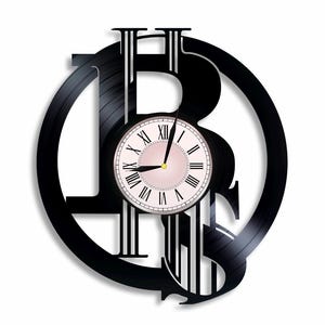 May include: Black vinyl record clock with a Bitcoin symbol design. The clock face has Roman numerals and a pink background.