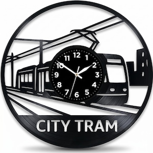 May include: Black wall clock with a city tram design. The clock face is black with white numerals and hands. The words "CITY TRAM" are at the bottom. The clock is a circular shape.