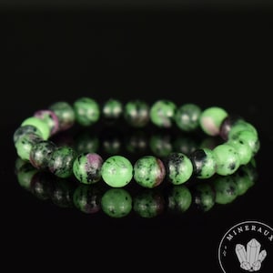 Peut inclure: Un bracelet en pierres précieuses vertes, noires et roses avec des perles rondes. Le bracelet est fait de pierres naturelles et est un beau bijou.