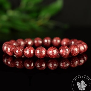 May include: A red gemstone bracelet with faceted beads. The bracelet is made of natural stones and is approximately 8 inches in length.
