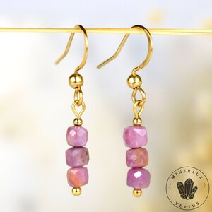 Peut inclure: Une paire de boucles d'oreilles en or avec trois perles de pierres précieuses roses sur chaque boucle d'oreille.