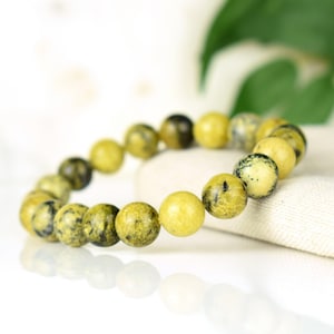 May include: A yellow and green gemstone bracelet with round beads.