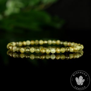 May include: A green and yellow gemstone bracelet with faceted beads. The bracelet is made of natural stones and is approximately 18 cm in length.