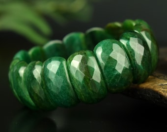 Può includere: Un bracciale composto da molteplici perle di pietra preziosa verde, arrotondate e sfaccettate. Ogni perla presenta una superficie lucida con un taglio geometrico, mostrando tonalità verde smeraldo e bosco con sottili variazioni naturali.