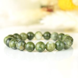 May include: A green jade stone bracelet with round beads. The beads have a mottled green and white pattern.