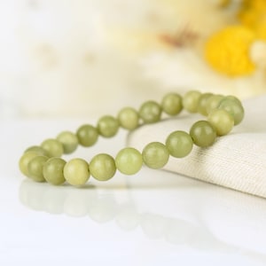 May include: A green jade stone bracelet with round beads.