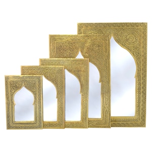 May include: Set of five gold-toned metal mirrors with intricate Moroccan-style designs. The mirrors are arranged in descending size, with the largest mirror at the back and the smallest mirror at the front.