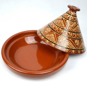 May include: A terracotta-colored tagine pot with a conical lid. The lid is decorated with geometric patterns in yellow and black. The base is a wide, shallow dish. The tagine is designed for slow cooking and serving Moroccan dishes.