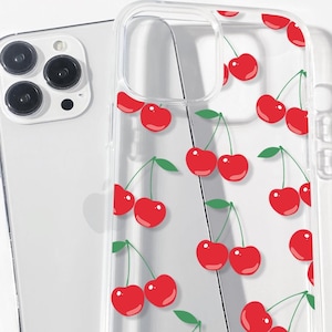 May include: A clear phone case with a red cherry pattern. The case is designed for an iPhone with a camera bump.