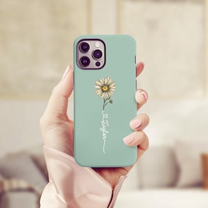 May include: A light blue phone case with a white daisy and the word "Taylor" written in cursive.
