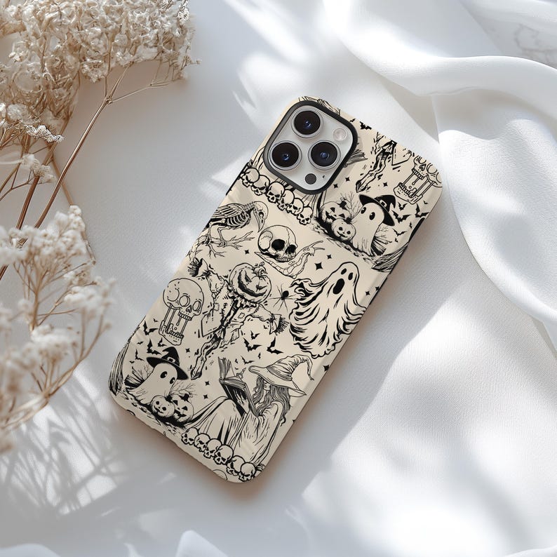 May include: A phone case with a Halloween-themed design. The case features a repeating pattern of black and white illustrations, including ghosts, skulls, bats, and witches. The case is beige and has a glossy finish.