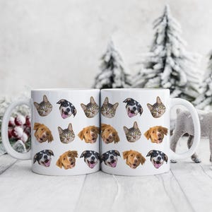 May include: Two white ceramic mugs with a repeating pattern of cat and dog faces. The mugs have black handles and are filled with a white liquid.