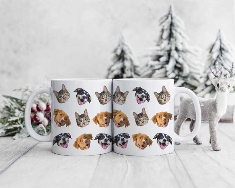 May include: Two white ceramic mugs with a repeating pattern of cat and dog faces. The mugs have black handles and are filled with a white liquid.
