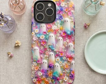 May include: A colorful phone case featuring a design of white ghost figures surrounded by vibrant flowers in shades of pink, purple, yellow, and blue. The case has a black border and a camera cutout.