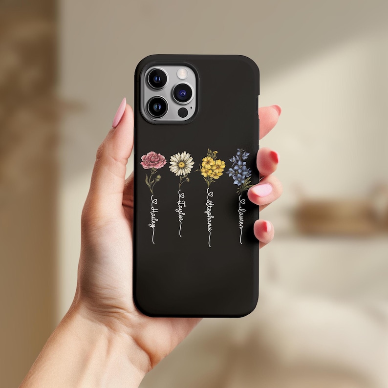 May include: Black iPhone case featuring a floral design with the names "Hailey", "Taylor", "Stephanie", and "Lauren" written vertically on the back.