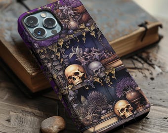 May include: A purple and black phone case with a gothic design featuring skulls, flowers, and books. The case has a raised lip around the camera lens.