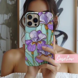 May include: A phone case with a stained glass design featuring purple iris flowers on a light blue background.
