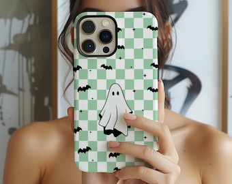 May include: A green and white checkered phone case with a ghost and bats. The case has a black camera cutout and a white background.