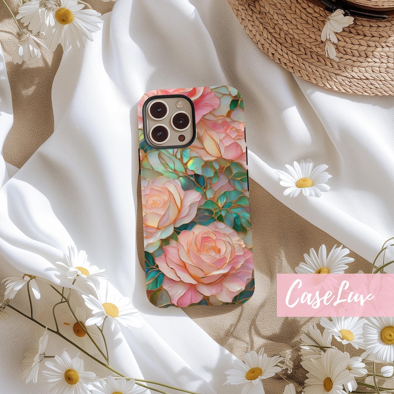 May include: A phone case with a floral design featuring pink and white roses, green leaves, and a stained glass effect. The case is designed for an iPhone with a camera bump.