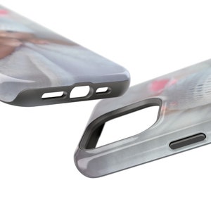 Peut inclure: Deux coques de smartphone, l'une mise au point, pr&eacute;sentant un design aux couleurs douces. Les coques ont un bord gris et une finition brillante. Le motif sur la coque semble &ecirc;tre une image de style aquarelle avec des teintes roses et blanches.