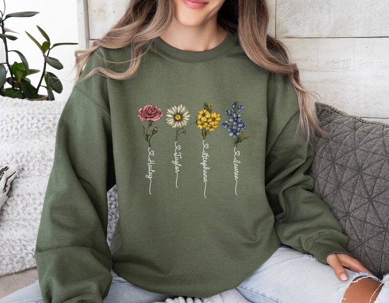 Pu&ograve; includere: Una felpa verde con un disegno floreale e i nomi "Hailey", "Taylor", "Stephanie" e "Lauren" scritti sotto i fiori.