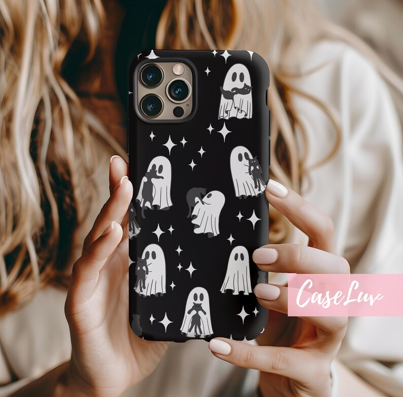 May include: Black phone case featuring a pattern of white ghosts and star shapes. The ghosts have various designs, some with cats. The case has a glossy finish and a camera cutout. The text "Case Luv" is in the bottom right corner.