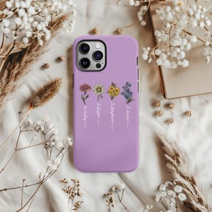 May include: A lavender phone case featuring a floral design with the names "Savannah", "Stephanie", "Taylor", and "Holley" written beneath the flowers.