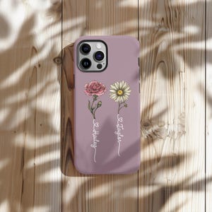 May include: A purple phone case featuring a floral design. The flowers are a pink carnation and a white daisy. The names "Hailey" and "Taylor" are inscribed on the case.