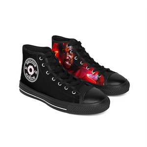 May include: Black high-top sneakers with white laces and a black toe cap. One shoe features a portrait in red and orange hues, while the other displays a circular logo with the text "Shogun Harlem".