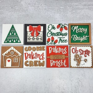 May include: Eight wooden signs with Christmas and baking themes. The signs feature a Christmas tree, a gift box, a gingerbread house, a cookie baking crew, baking spirits, a gingerbread man, and two signs with Christmas greetings.