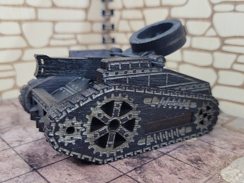 May include: A black wooden toy tank with a detailed design. The tank has a large wheel in the back and a smaller wheel in the front. The tank is made of wood and has a black finish.